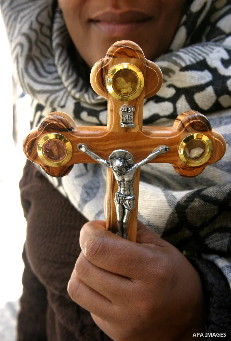 A Christian worshipper holds a cross in the Church of the Holy Sepulchre during the Eastern and Orthodox Church's Good Friday procession in the Old City of Jerusalem April 13, 2012. Photo by Mahfouz Abu Turk