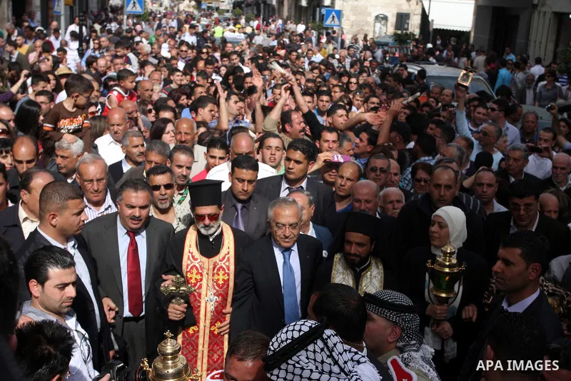 Palestinian Prime Minister Salam Fayyad takes part in the "Holy Fire" procession on the eve of Orthodox Easter in the West Bank city of Ramallah on April 14, 2012. The date of Orthodox Easter is calculated differently th...