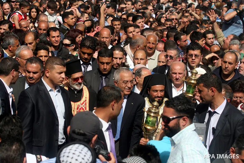 Palestinian Prime Minister Salam Fayyad takes part in the "Holy Fire" procession on the eve of Orthodox Easter in the West Bank city of Ramallah on April 14, 2012. The date of Orthodox Easter is calculated differently th...
