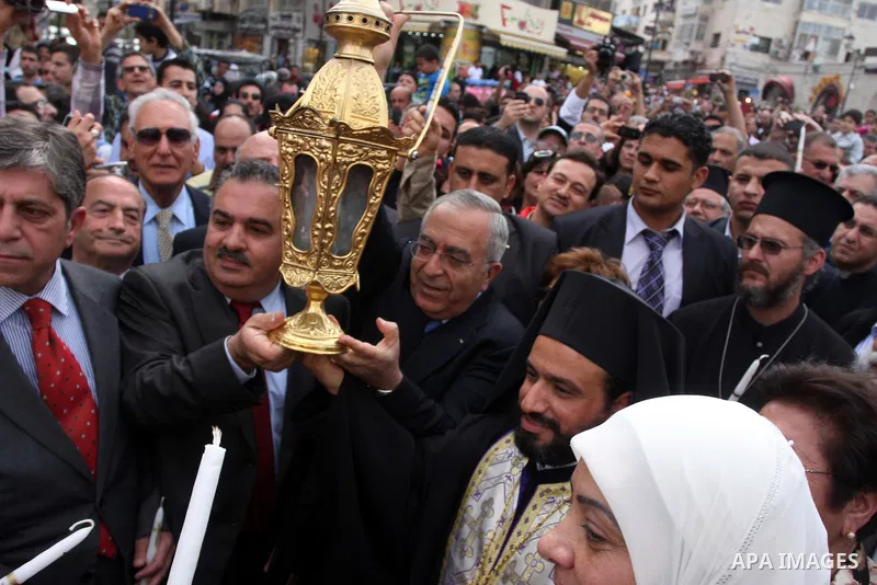 Palestinian Prime Minister Salam Fayyad takes part in the "Holy Fire" procession on the eve of Orthodox Easter in the West Bank city of Ramallah on April 14, 2012. The date of Orthodox Easter is calculated differently th...