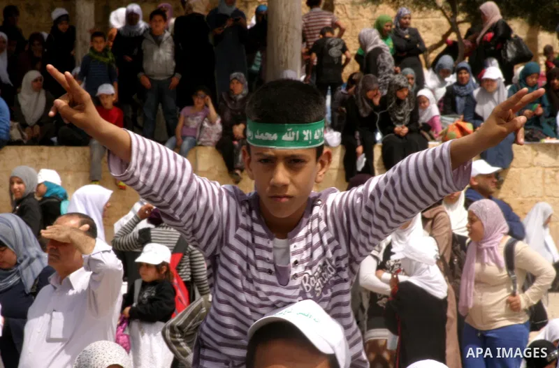 Palestinians gathers in front of Jerusalem's Dome of the Rock mosque inside the courtyard of the Al-Aqsa mosques compound, Islam's third holiest site, during a ceremony marking the international Children's Day on April 1...