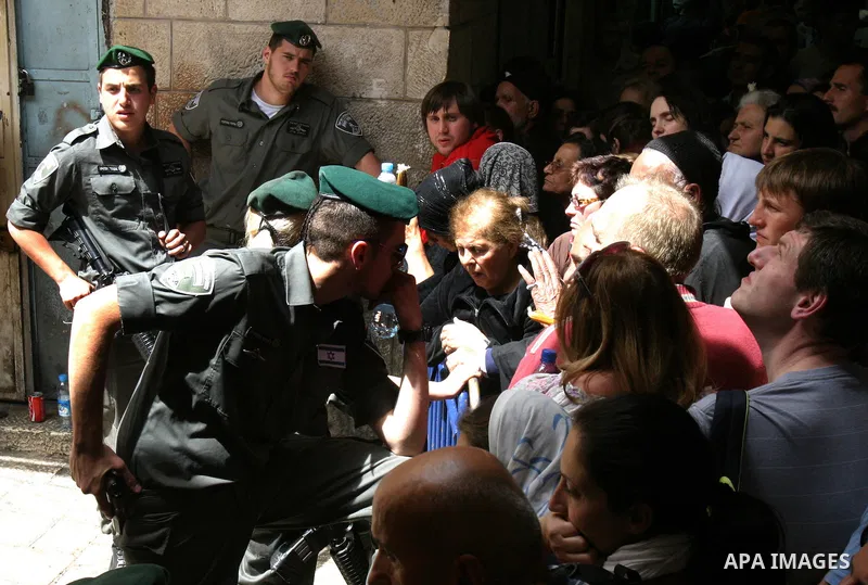 Palestinian Christians from the Greek Orthodox Church chant and sing in the streets with candles and crosses during the Easter Holy Fire ritual in the Old City of Jerusalem on April 14, 2012. during the 'Holy Fire' cerem...