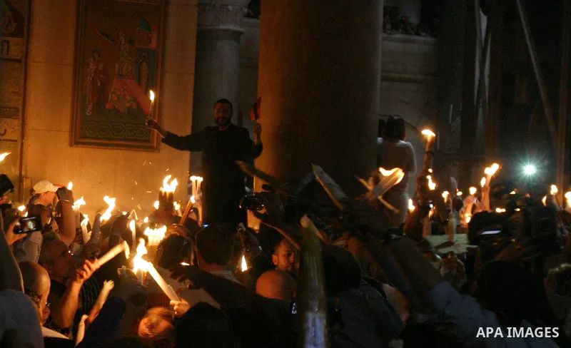Christian Orthodox worshipers hold up candles lit from the 'Holy Fire' as thousands gather in the Church of the Holy Sepulchre in Jerusalem's old city on April 14, 2012 during the 'Holy Fire' ceremony on the eve of the O...
