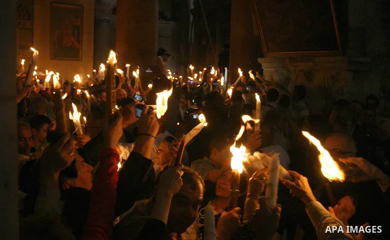 Christian Orthodox worshipers hold up candles lit from the 'Holy Fire' as thousands gather in the Church of the Holy Sepulchre in Jerusalem's old city on April 14, 2012 during the 'Holy Fire' ceremony on the eve of the O...