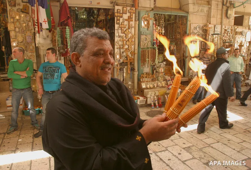 Palestinian Christians from the Greek Orthodox Church chant and sing in the streets with candles and crosses during the Easter Holy Fire ritual in the Old City of Jerusalem on April 14, 2012. during the 'Holy Fire' cerem...
