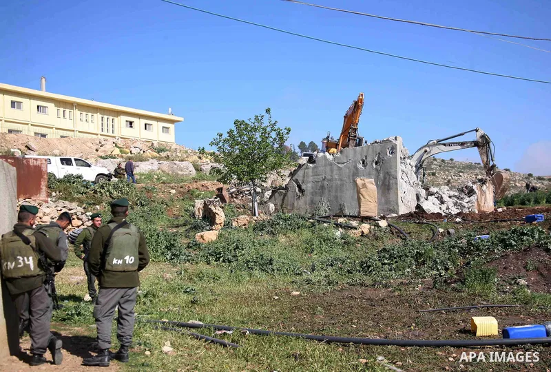 Israeli border police officers stand guard as demolition vehicles destroy a man-made reservoir on a Palestinian farm near the West Bank city of Hebron, on Apr. 16, 2012. Reports state that tensions rose as Palestinian ho...