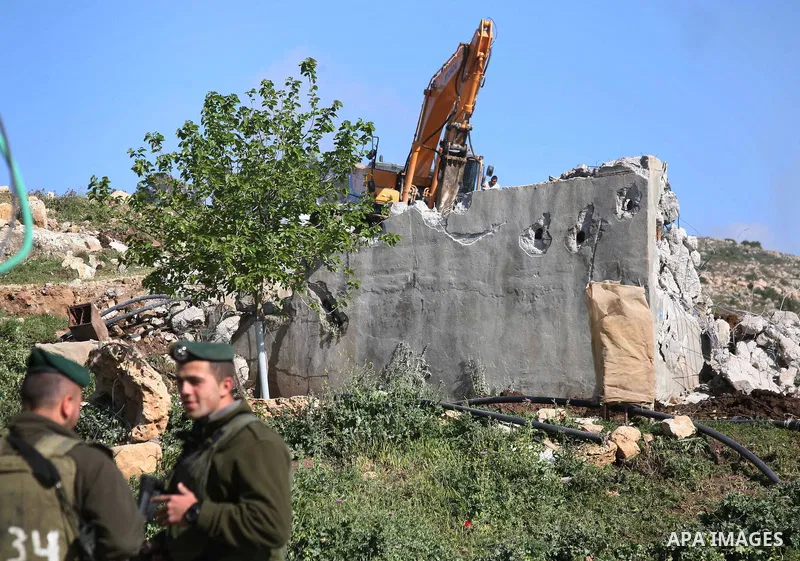 Israeli border police officers stand guard as demolition vehicles destroy a man-made reservoir on a Palestinian farm near the West Bank city of Hebron, on Apr. 16, 2012. Reports state that tensions rose as Palestinian ho...