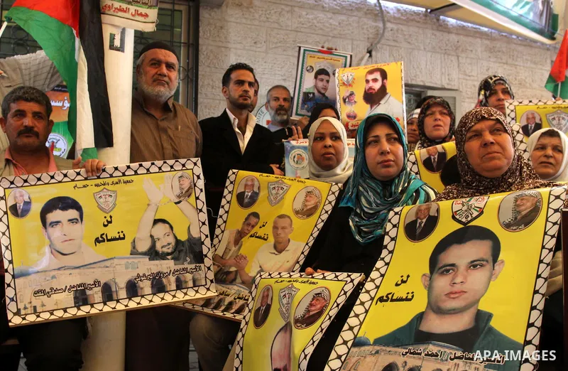 Palestinians hold up portrait of incarcerated relatives during a protest calling for the release of Palestinian prisoners held in Israeli jails inside the grounds of the Red Cross office in Gaza City on April 16, 2012. S...
