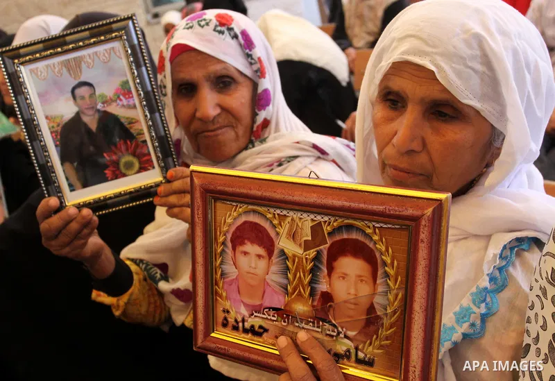 Palestinian women hold up portrait of incarcerated relatives during a protest calling for the release of Palestinian prisoners held in Israeli jails inside the grounds of the Red Cross office in Gaza City on April 16, 20...