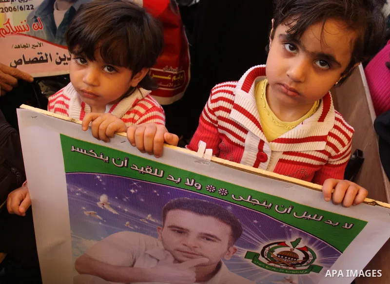 Palestinian children hold up portrait of incarcerated relatives during a protest calling for the release of Palestinian prisoners held in Israeli jails inside the grounds of the Red Cross office in Gaza City on April 16,...