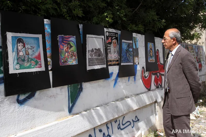 Palestinians look at the murals during a protest during a protest calling for the release of Palestinian prisoners held in Israeli jails inside the grounds of the Red Cross office in Gaza City on April 16, 2012. Some 1,6...