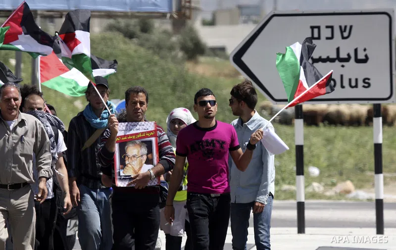 Palestinians and foreign activists plant olive trees during a demonstration marking Palestinian Prisoners' Day ,in the Hawara checkpoint near the West Bank city of Nablus, Monday, April 16, 2012. Photo by Wagdi Eshtayah