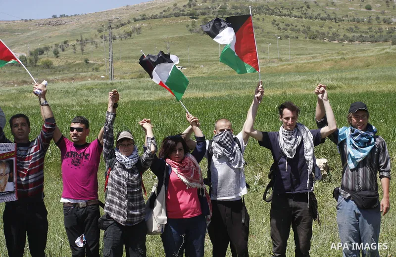 Palestinians and foreign activists plant olive trees during a demonstration marking Palestinian Prisoners' Day ,in the Hawara checkpoint near the West Bank city of Nablus, Monday, April 16, 2012. Photo by Wagdi Eshtayah