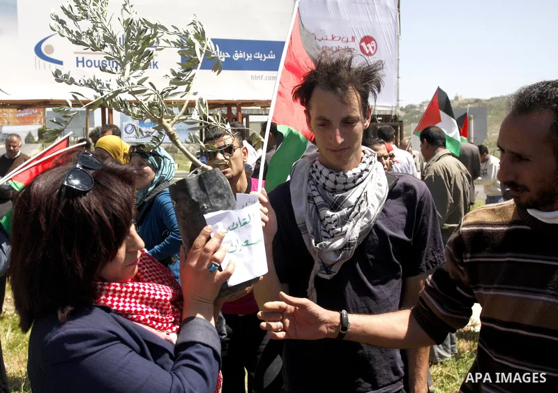 Palestinians and foreign activists hold Palestinian flag during a demonstration marking Palestinian Prisoners' Day ,in the Hawara checkpoint near the West Bank city of Nablus, Monday, April 16, 2012. Photo by Wagdi Eshta...