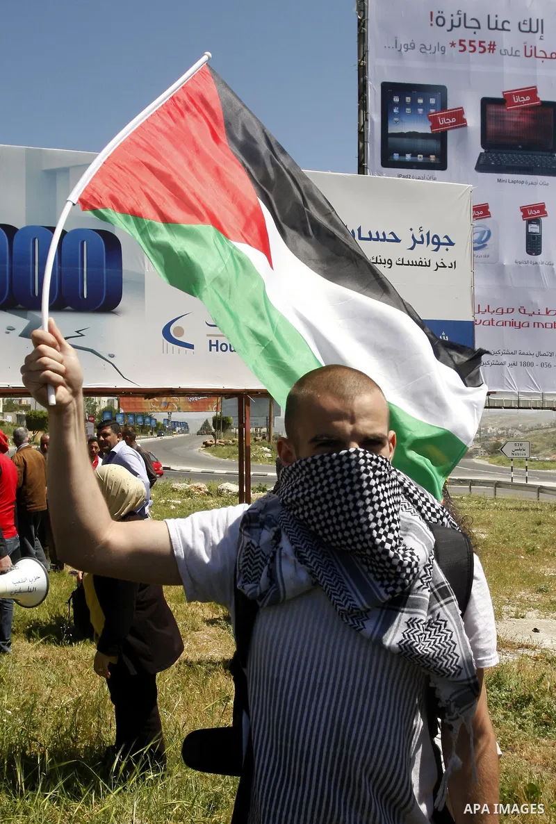 Palestinians and foreign activists plant olive trees during a demonstration marking Palestinian Prisoners' Day ,in the Hawara checkpoint near the West Bank city of Nablus, Monday, April 16, 2012. Photo by Wagdi Eshtayah