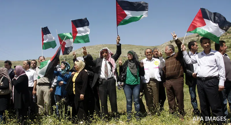 Palestinians and foreign activists plant olive trees during a demonstration marking Palestinian Prisoners' Day ,in the Hawara checkpoint near the West Bank city of Nablus, Monday, April 16, 2012. Photo by Wagdi Eshtayah