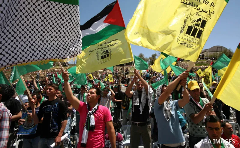 Palestinian protesters wave national flags during a rally in West Bank city of Hebron on April 17, 2012 in solidarity with Palestinian prisoners held in Israel. Some 1,200 Palestinian prisoners held in Israeli jails have...