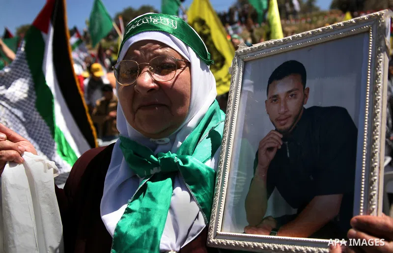 Palestinian protesters wave national flags during a rally in West Bank city of Hebron on April 17, 2012 in solidarity with Palestinian prisoners held in Israel. Some 1,200 Palestinian prisoners held in Israeli jails have...