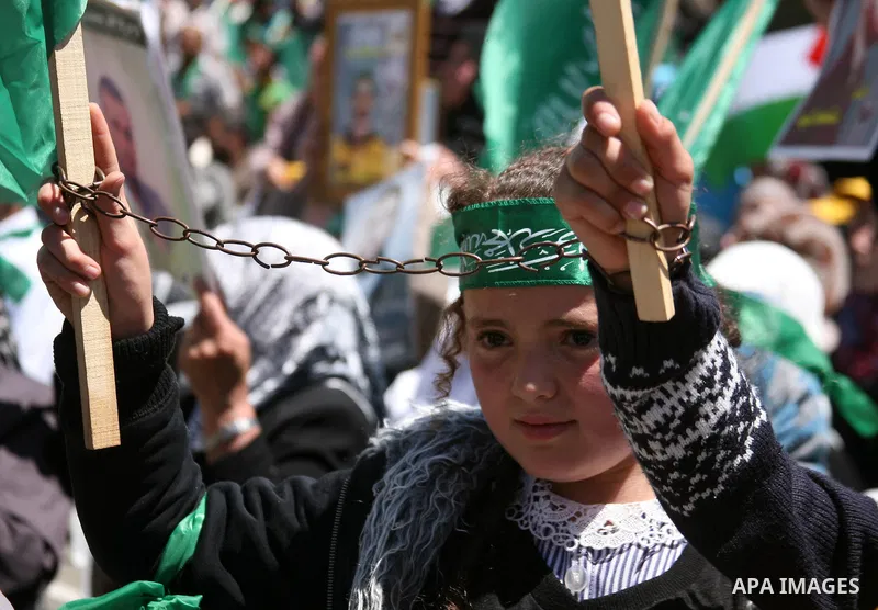 Palestinian protesters wave national flags during a rally in West Bank city of Hebron on April 17, 2012 in solidarity with Palestinian prisoners held in Israel. Some 1,200 Palestinian prisoners held in Israeli jails have...