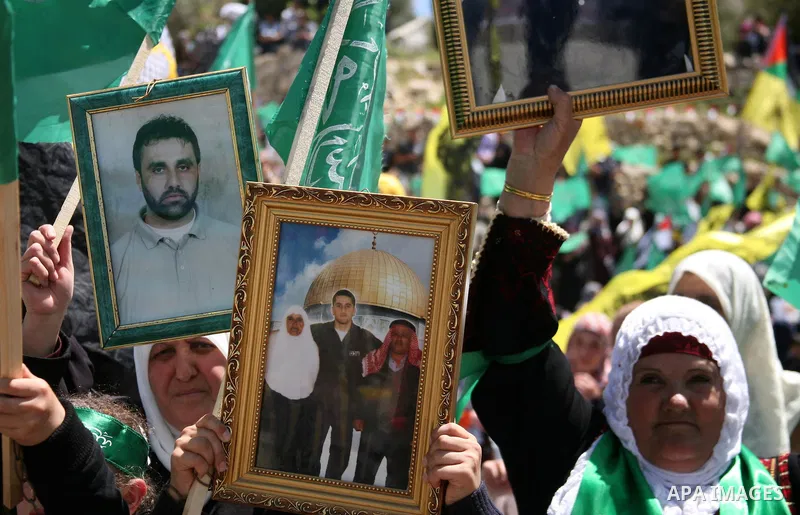 Palestinian protesters wave national flags during a rally in West Bank city of Hebron on April 17, 2012 in solidarity with Palestinian prisoners held in Israel. Some 1,200 Palestinian prisoners held in Israeli jails have...