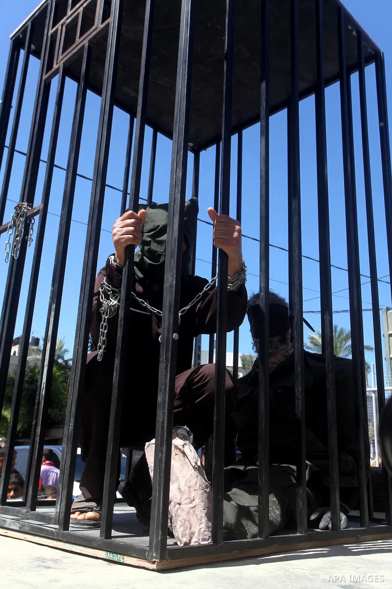 Palestinian boys with handcuffs attend a rally to commemorate the Palestinian Prisoner Day in Gaza City, on April 17, 2012. The Israeli Prisons Authority said on Tuesday in a written statement that 2,300 Palestinian pris...