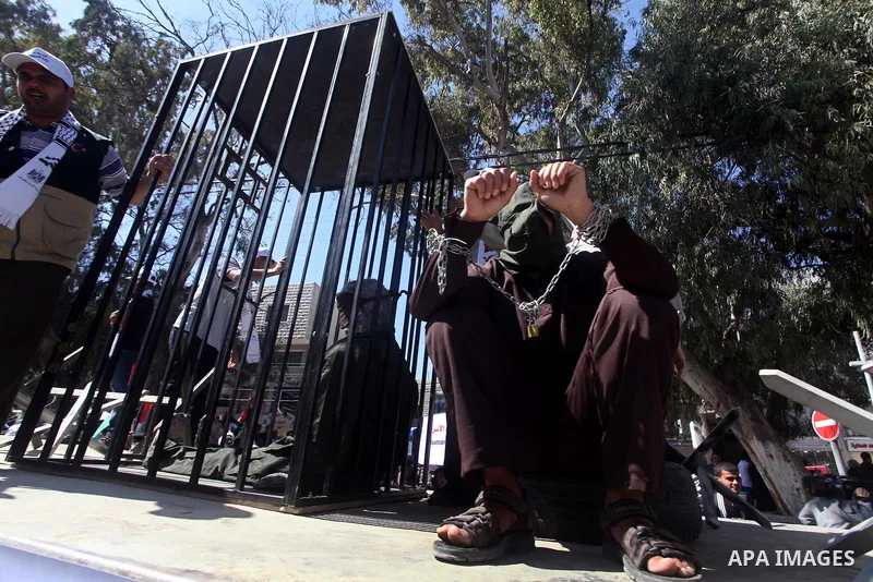 Palestinian boys with handcuffs attend a rally to commemorate the Palestinian Prisoner Day in Gaza City, on April 17, 2012. The Israeli Prisons Authority said on Tuesday in a written statement that 2,300 Palestinian pris...