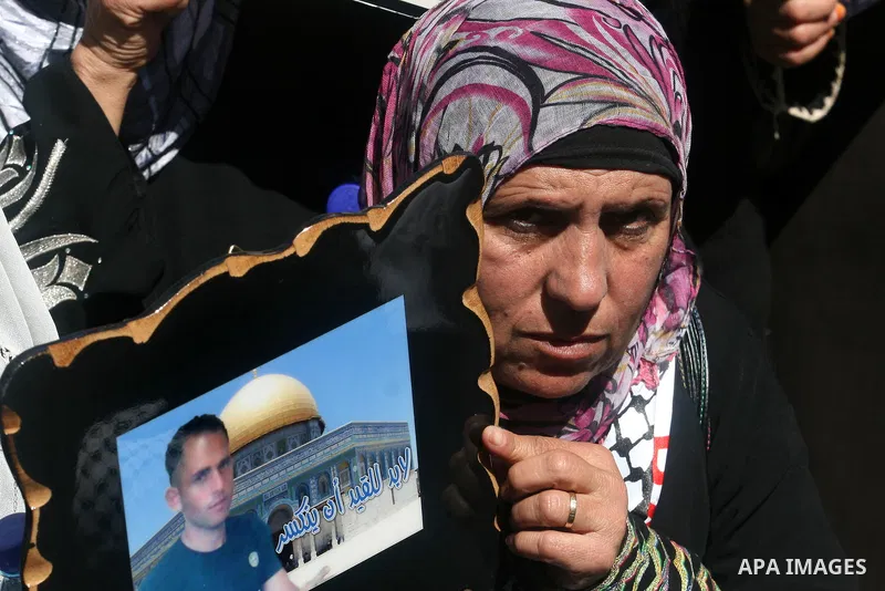 Palestinians hold a photograph of a prisoner jailed in Israel, during a rally marking the annual prisoners' day in the West Bank city of Ramallah, Tuesday, April 17, 2012. Hundreds of Palestinian prisoners held by Israel...