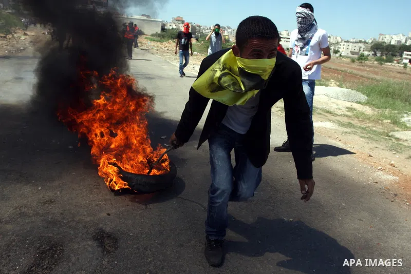 A Palestinian protester accidentally sets himself on fire while throwing a Molotov cocktail towards the Israeli soldiers during clashes following a demonstration to mark the Prisoners' Day near Israels Ofer prison, betw...