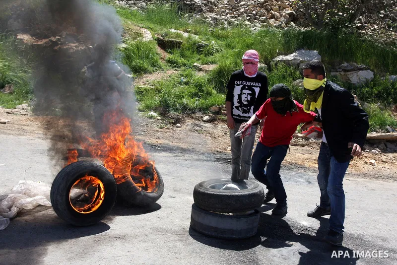A Palestinian protester accidentally sets himself on fire while throwing a Molotov cocktail towards the Israeli soldiers during clashes following a demonstration to mark the Prisoners' Day near Israels Ofer prison, betw...