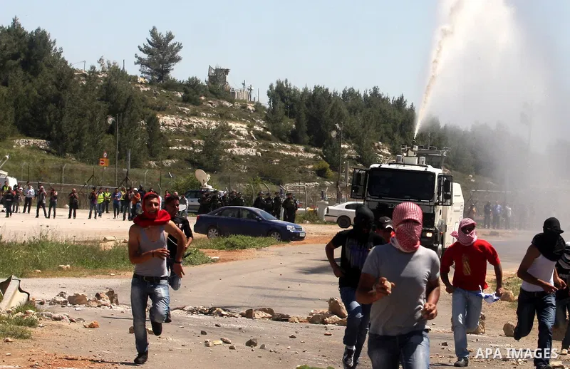 A Palestinian protester walks amid teargas fired by Israeli soldiers during a demonstration to mark the Prisoners' Day near Israels Ofer prison, between Jerusalem and Ramallah on April 17, 2012. At least 1,200 Palestini...