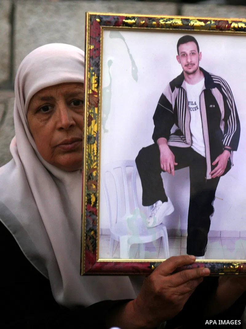 Palestinians hold portraits of relatives jailed in Israeli prisons as they protest to demand for their release during a demonstration to mark Prisoners' Day outside the Damascus gate, in the old city of Jerusalem on Apri...