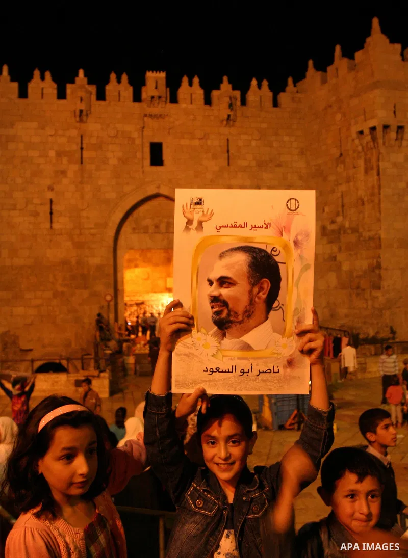 Palestinians hold portraits of relatives jailed in Israeli prisons as they protest to demand for their release during a demonstration to mark Prisoners' Day outside the Damascus gate, in the old city of Jerusalem on Apri...
