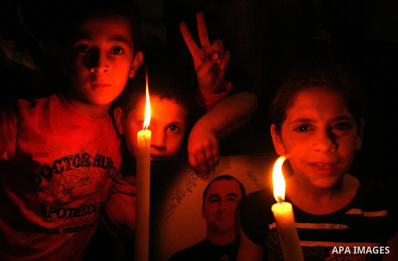 Palestinians hold portraits of relatives jailed in Israeli prisons as they protest to demand for their release during a demonstration to mark Prisoners' Day outside the Damascus gate, in the old city of Jerusalem on Apri...