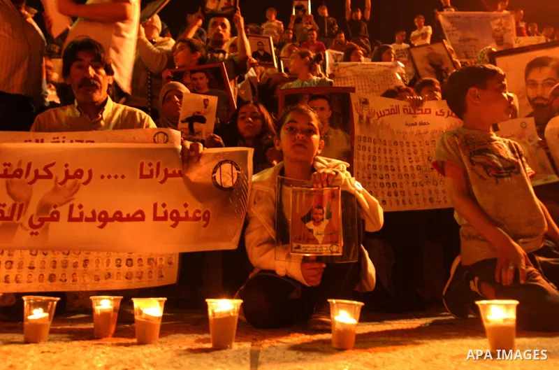 Palestinians hold portraits of relatives jailed in Israeli prisons as they protest to demand for their release during a demonstration to mark Prisoners' Day outside the Damascus gate, in the old city of Jerusalem on Apri...