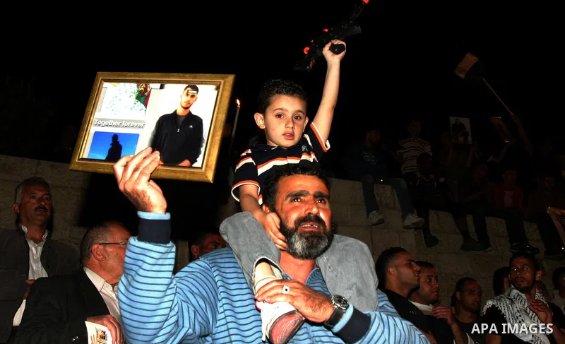 Palestinians hold portraits of relatives jailed in Israeli prisons as they protest to demand for their release during a demonstration to mark Prisoners' Day outside the Damascus gate, in the old city of Jerusalem on Apri...