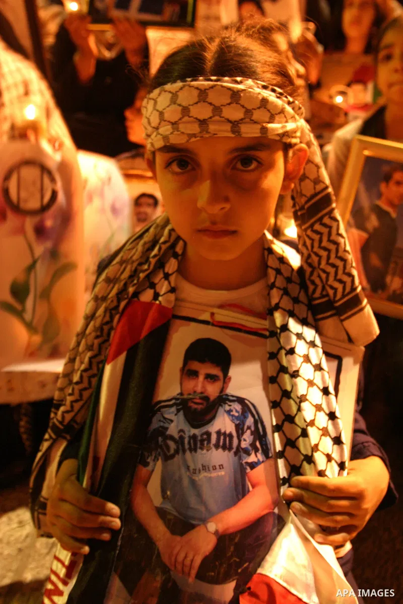 Palestinians hold portraits of relatives jailed in Israeli prisons as they protest to demand for their release during a demonstration to mark Prisoners' Day outside the Damascus gate, in the old city of Jerusalem on Apri...