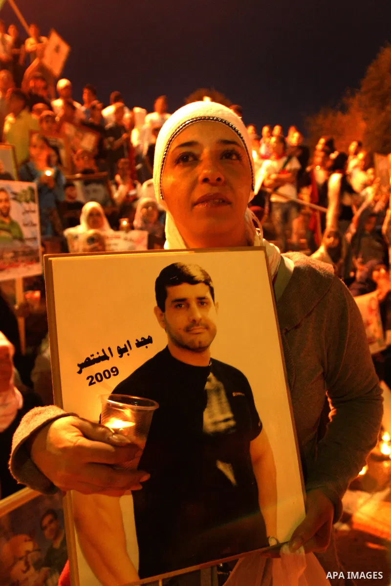 Palestinians hold portraits of relatives jailed in Israeli prisons as they protest to demand for their release during a demonstration to mark Prisoners' Day outside the Damascus gate, in the old city of Jerusalem on Apri...