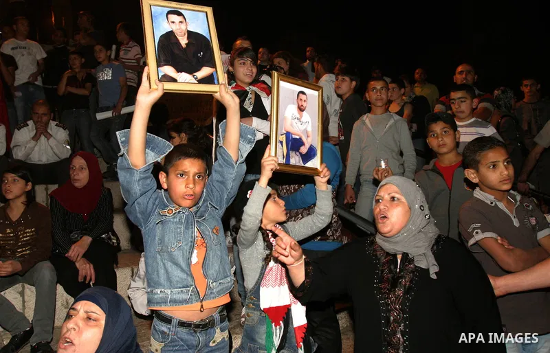 Palestinians hold portraits of relatives jailed in Israeli prisons as they protest to demand for their release during a demonstration to mark Prisoners' Day outside the Damascus gate, in the old city of Jerusalem on Apri...