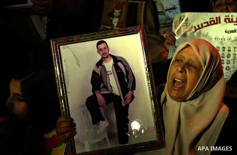 Palestinians hold portraits of relatives jailed in Israeli prisons as they protest to demand for their release during a demonstration to mark Prisoners' Day outside the Damascus gate, in the old city of Jerusalem on Apri...