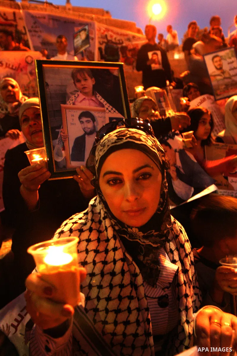 Palestinians hold portraits of relatives jailed in Israeli prisons as they protest to demand for their release during a demonstration to mark Prisoners' Day outside the Damascus gate, in the old city of Jerusalem on Apri...