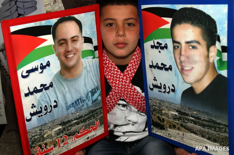 Palestinians hold portraits of relatives jailed in Israeli prisons as they protest to demand for their release during a demonstration to mark Prisoners' Day outside the Damascus gate, in the old city of Jerusalem on Apri...