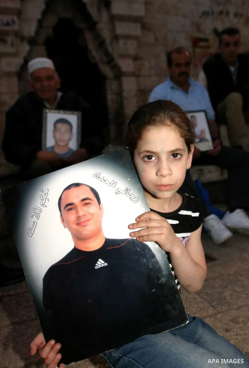 Palestinians hold portraits of relatives jailed in Israeli prisons as they protest to demand for their release during a demonstration to mark Prisoners' Day outside the Damascus gate, in the old city of Jerusalem on Apri...