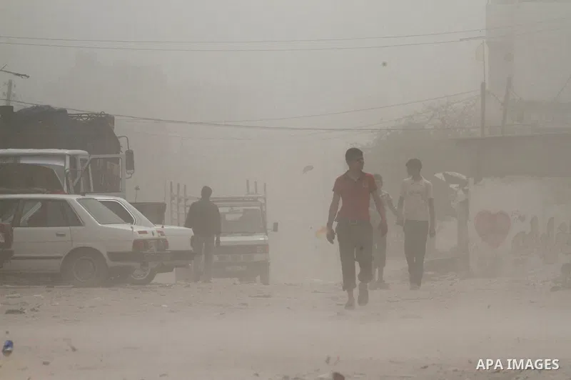 Palestinians walk on the street during hot winds and sand storms in Gaza City on April 18, 2012. Photo by Mohammed Asad