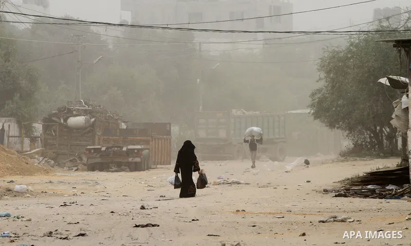 Palestinians walk on the street during hot winds and sand storms in Gaza City on April 18, 2012. Photo by Mohammed Asad