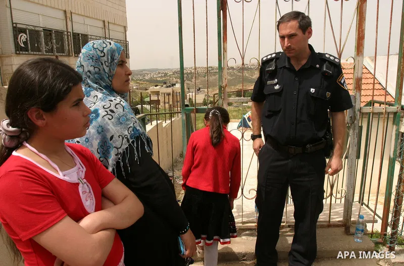 Israeli police stand guard as Palestinian members of the Khaled Natsheh household remove household items after being forced to hand over their home to Jewish settlers in the Israeli annexed east Jerusalem neighbourhood o...