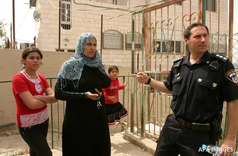 Israeli police stand guard as Palestinian members of the Khaled Natsheh household remove household items after being forced to hand over their home to Jewish settlers in the Israeli annexed east Jerusalem neighbourhood o...