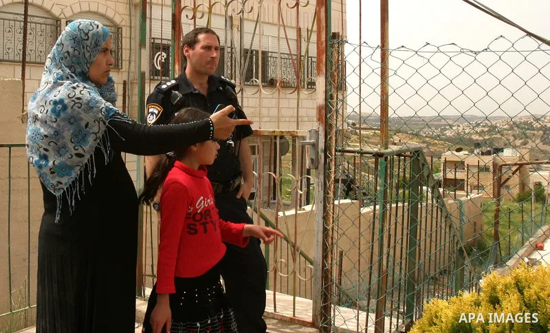 Israeli police stand guard as Palestinian members of the Khaled Natsheh household remove household items after being forced to hand over their home to Jewish settlers in the Israeli annexed east Jerusalem neighbourhood o...