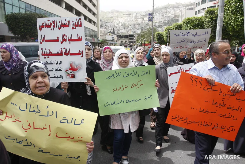 Palestinians hold banners and flags during a march calling for the imposition of the law of collateral social worker for the Palestinian, in April 19, 2012 in the West Bank city of Nablus. Photo by Wagdi Eshtayah.