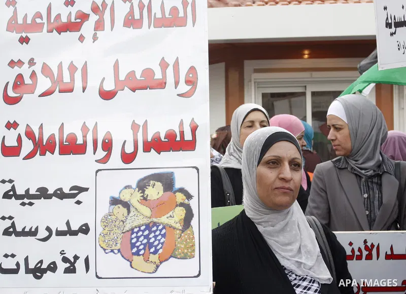 Palestinians hold banners and flags during a march calling for the imposition of the law of collateral social worker for the Palestinian, in April 19, 2012 in the West Bank city of Nablus. Photo by Wagdi Eshtayah.