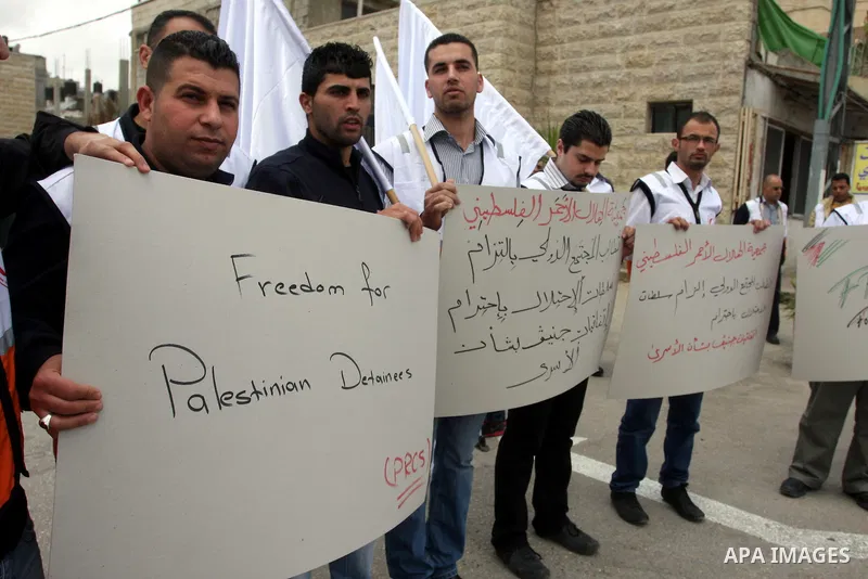 Staff of the Palestinian Red Crescent Society, wave flags and banners during a rally in solidarity with prisoners in Israeli jails, in the West Bank city of Ramallah, April 19, 2012. Photo by Issam Rimawi